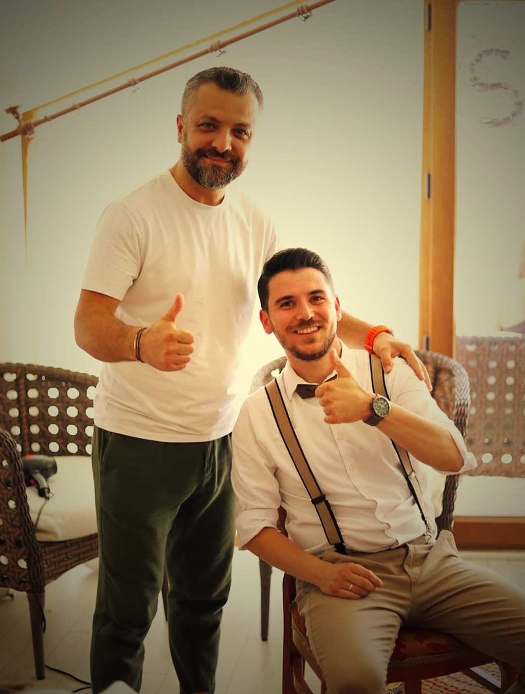 Berber ve müşterisi tıraş sonrası başparmak işaretiyle gülümsüyor